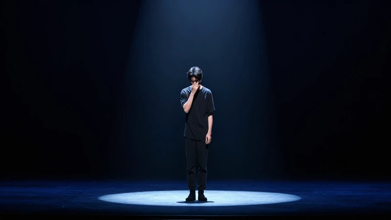 Figura solitaria en escena, atmósfera dramática y melancólica