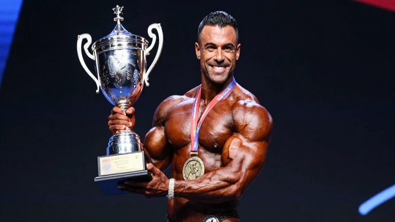Cuerpo de fisicoculturista musculoso con gran trofeo