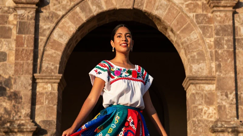 Mujer mexicana atractiva bajo un arco antiguo
