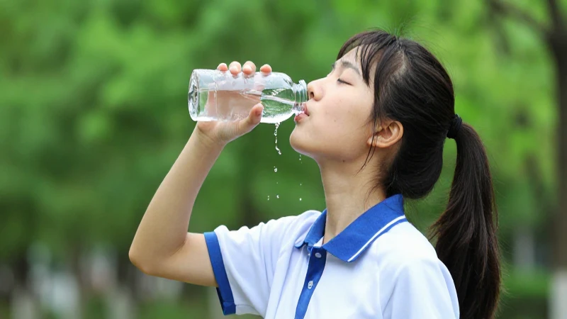 Joven estudiante dinámico bebiendo agua con estética vibrante